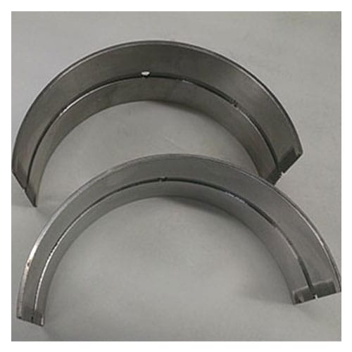 Two steel black aluminum lined bearings against white flat surface.